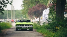 Зеленый Plymouth Barracuda разгоняется по ухабистой дороге